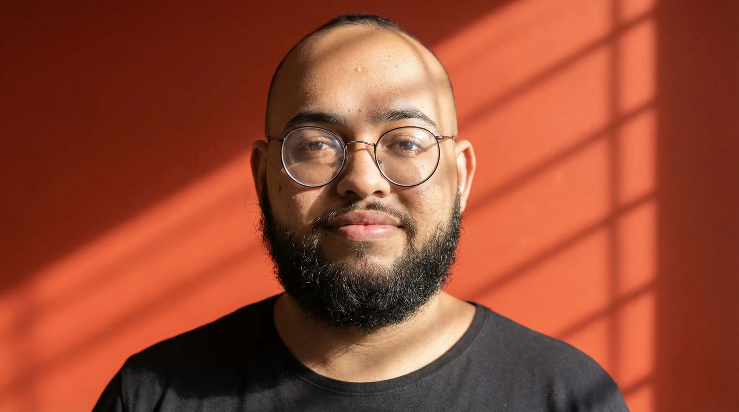 Marlon Fernandes, founder of Londe, facing the camera against an orange background in natural window light